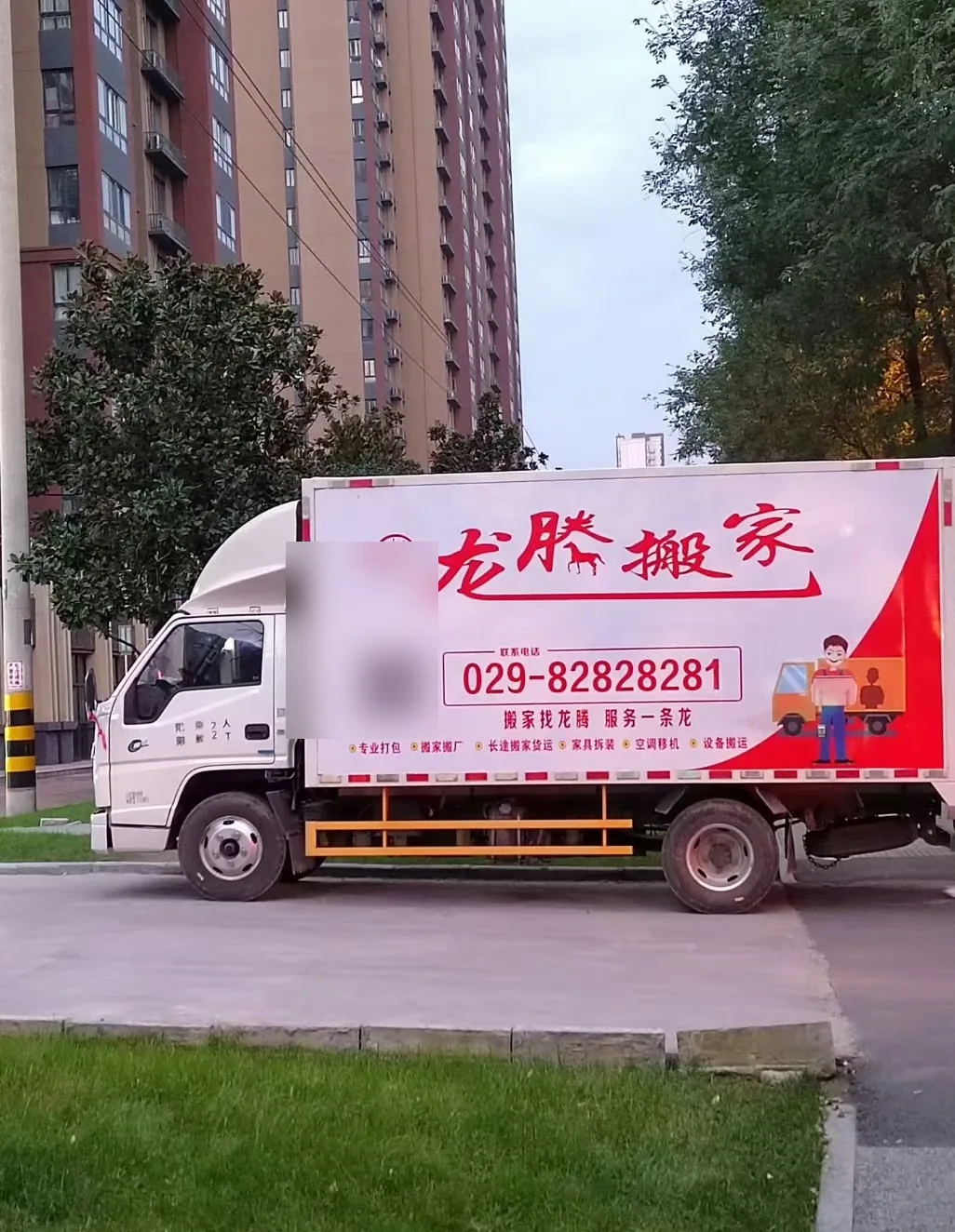 龙腾搬家货车停靠在街边准备装卸物品