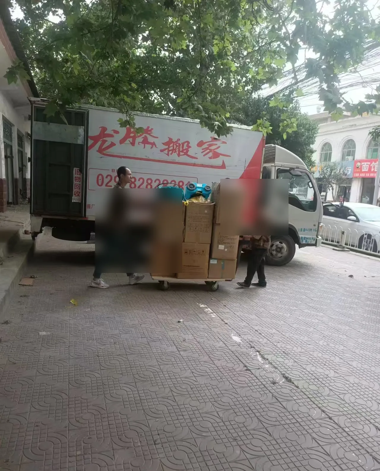 龙腾搬家货车在街道旁装运打包物品
